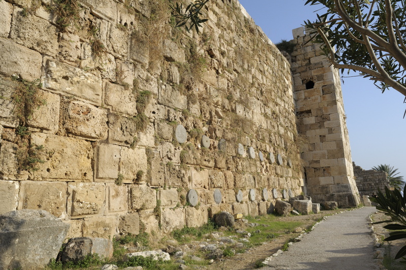 Observer les restes de colonnes de granit qui renforcent la muraille