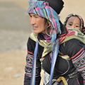 Bébé hmong curieux, sur le dos de sa maman